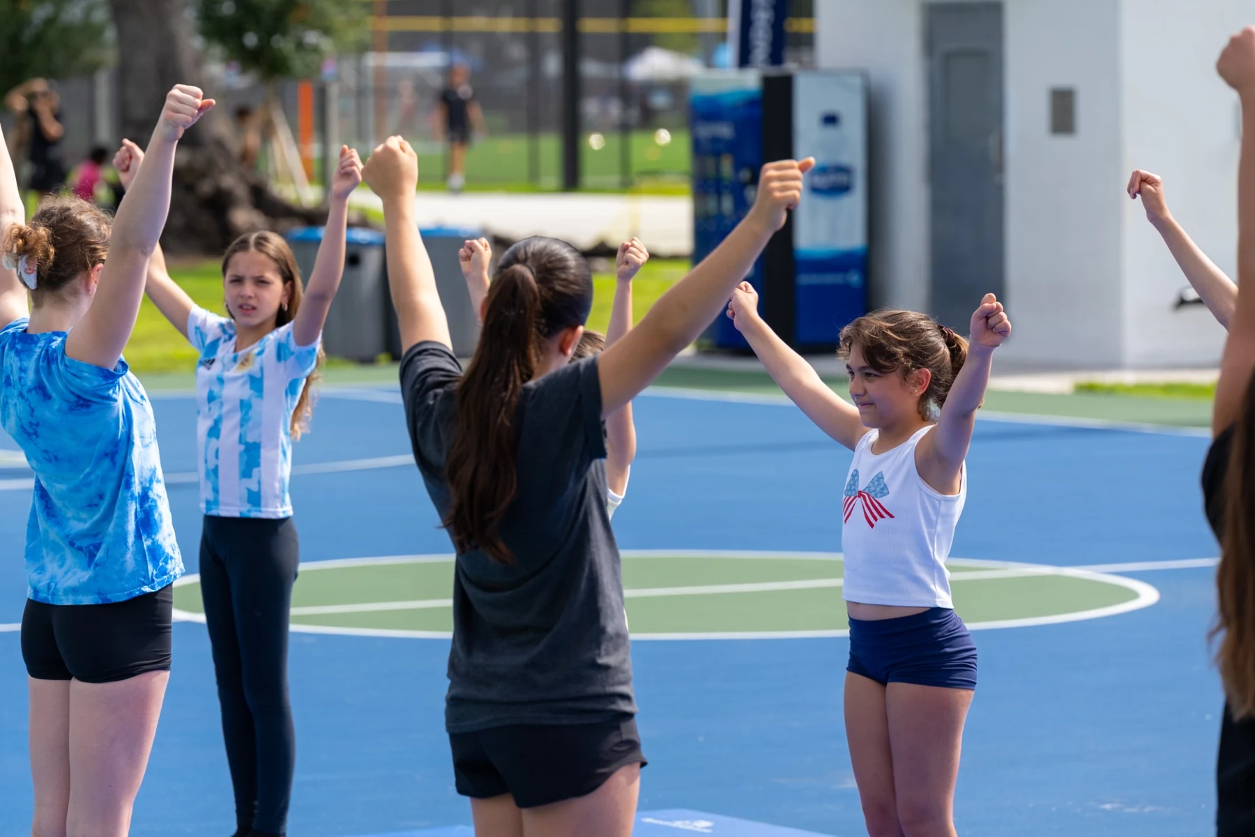 Girls practicing coordinated movements together during a group activity