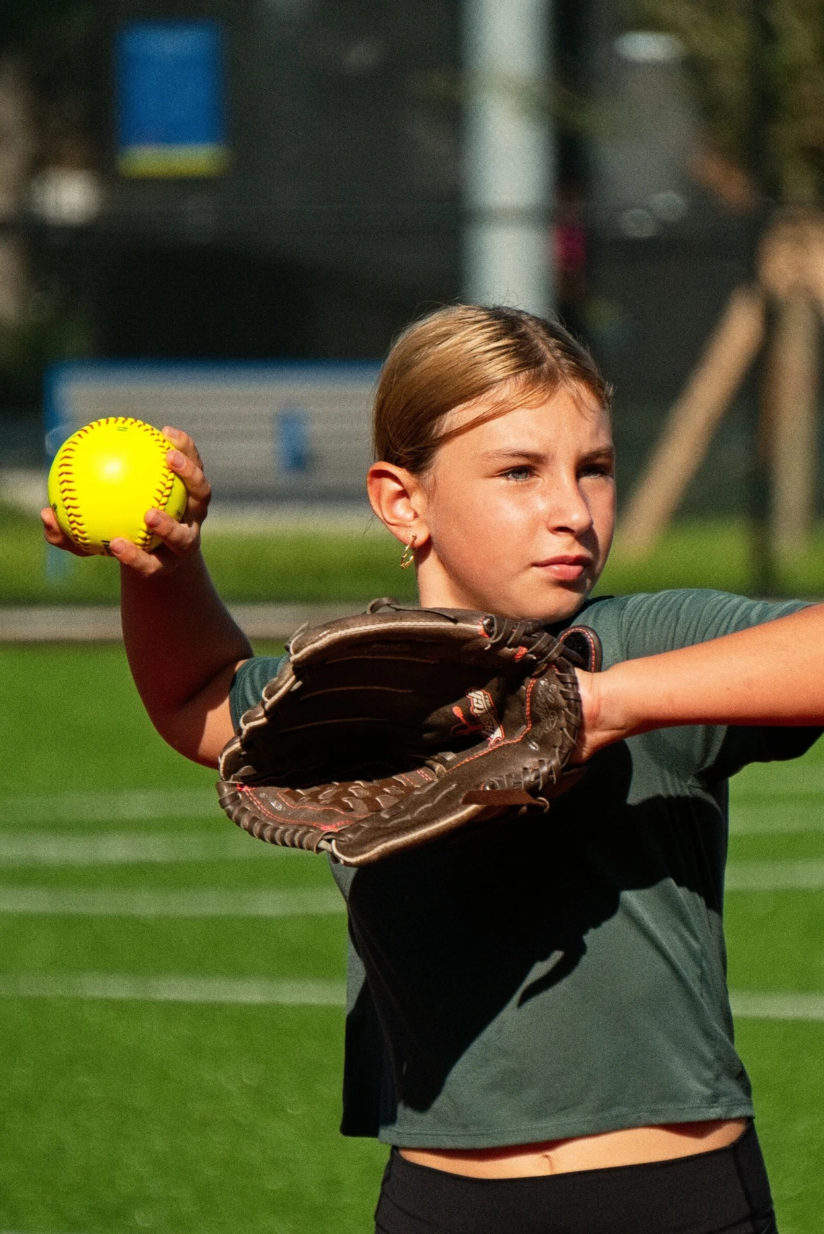 Girl preparing to throw a softball with her glove raised