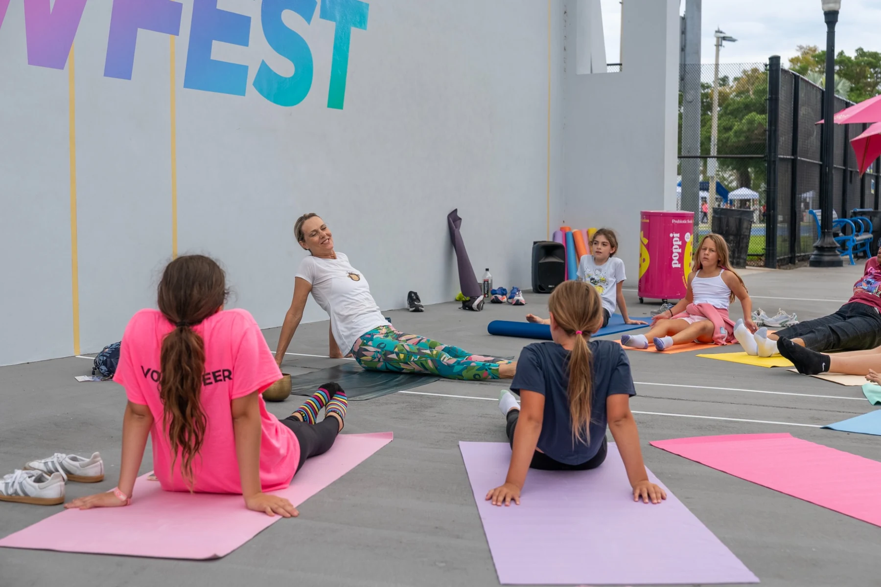 Girls following an instructor in a seated yoga and stretching session
